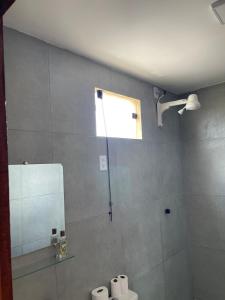 a bathroom with a shower and a toilet and a window at Flat Mirante da praia - piscinas naturais PE-AL in São José da Coroa Grande