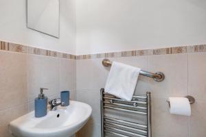 a bathroom with a sink and a towel at Isher 3 Bedroom, 2-Bathroom House with Parking in Uxbridge +48 photos
