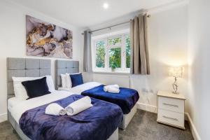 a bedroom with two beds and a window at Isher 3 Bedroom, 2-Bathroom House with Parking in Uxbridge