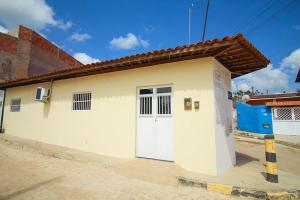 a small white building with a white door at Casa Jade Patacho in Pôrto de Pedras +14 photos
