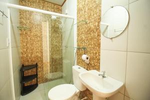 a bathroom with a toilet and a sink and a mirror at Casa Jade Patacho in Pôrto de Pedras