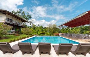 a swimming pool with chairs and a building at Villas Josipek in Fortuna