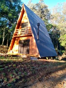 a house with a roof with a cross on it at Cabana Encanto da Mata in Santa Maria do Erval