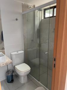 ein Badezimmer mit Toilette und Glasdusche in der Unterkunft Casa em condomínio na praia in Cabedelo
