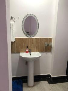 a bathroom with a white sink and a mirror at Del's Homes -Ruiru in Ruiru