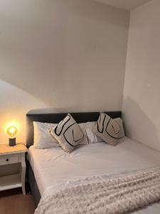 a bedroom with a bed with two pillows on it at SH Apartments in Hannover +15 photos
