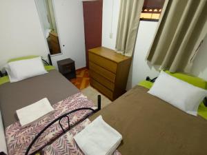 a room with two beds and a dresser in it at Sumaq Tika in Cusco
