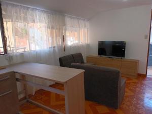 a living room with a table and a television at Sumaq Tika in Cusco