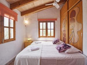 Un dormitorio con una cama con almohadas moradas. en Holiday Home in LLevant with private pool, en Maria de la Salut 32 fotos más