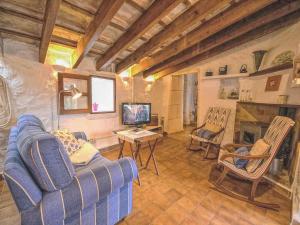 Una sala de estar con un sofá azul y un televisor en Holiday Home in LLevant with private pool, en Maria de la Salut