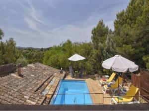 una piscina con dos sillas y dos sombrillas en Holiday Home in LLevant with private pool, en Maria de la Salut