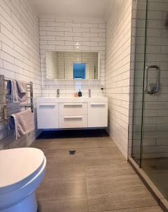 un bagno con un lavandino bianco e un water di Cosy Luxe --Modern 3 bedroom home in Johnsonville a Wellington