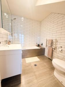 un bagno con un water, un lavandino e una vasca di Cosy Luxe --Modern 3 bedroom home in Johnsonville a Wellington Altre 24 foto