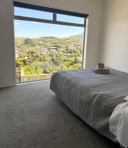 una camera da letto con una grande finestra con vista su una montagna di Cosy Luxe --Modern 3 bedroom home in Johnsonville a Wellington