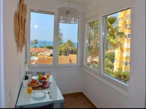 una cocina con 2 ventanas y una mesa con fruta. en Apartment with Sea Views in Mijas Costa, en Mijas Costa