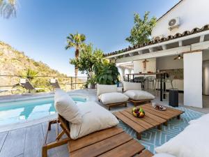 a patio with chairs and a swimming pool at Yoga and Relaxation Retreat in the Heart of Nature in Carratraca