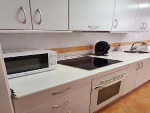 El EsparragalにあるCharming apartment with garden in Almeriaの白いキッチン(電子レンジ、シンク付)