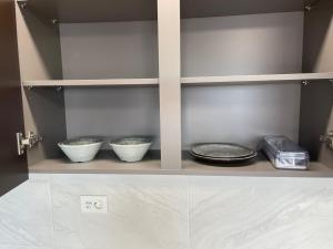 a shelf with three bowls and plates on it at 강릉 하이오션 경포 a203 in Gangneung +9 photos