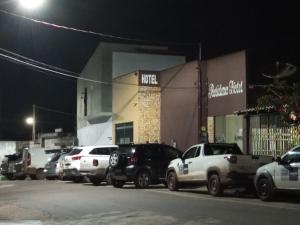 eine Gruppe von Autos, die vor einem Gebäude geparkt sind in der Unterkunft Residence hotel in Pinheiro