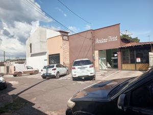ein Parkplatz mit vor einem Gebäude geparkten Autos in der Unterkunft Residence hotel in Pinheiro
