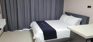 a bedroom with a bed with a black and white blanket at 강릉 하이오션 경포 a203 in Gangneung