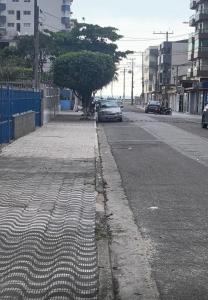 una strada vuota con un'auto parcheggiata sulla strada di Kitão Caiçara a Praia Grande