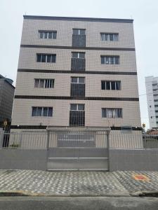 un edificio alto con una recinzione di fronte di Kitão Caiçara a Praia Grande Altre 5 foto