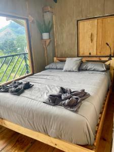 a large bed with towels on it in a bedroom at EB5 Escape Tzununa, Lake Atitlan Room #1 - two minute walk to the Lake in Santa Cruz La Laguna