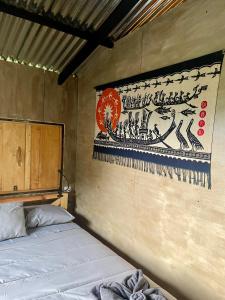 a room with a bed and a painting on the wall at EB5 Escape Tzununa, Lake Atitlan Room #1 - two minute walk to the Lake in Santa Cruz La Laguna
