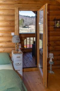 een slaapkamer met een bed en een deur naar een veranda bij Holiday house with a parking space Belo Selo, Gorski kotar - 24979 in Donja Slavica