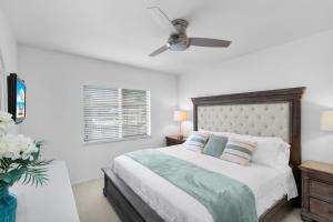 a white bedroom with a bed and a ceiling fan at Pirates Cove Marco Island, saltwater pool, bikes, water sports, paddle boards included! in Marco Island +36 photos