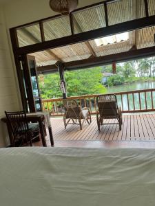 a room with a porch with chairs and a bed at À La Koh Kood Resort in Ko Kood