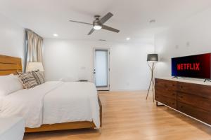 een slaapkamer met een bed en een flatscreen-tv bij Minimalist Modern 3Bed 3Bath House near the Rose Bowl in Pasadena in Pasadena