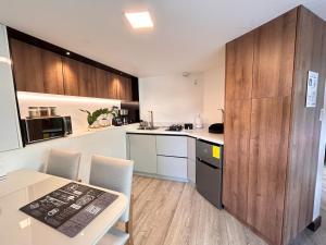 een keuken met houten kasten en een tafel met stoelen bij Suite de lujo con naturaleza y BBQ cerca de Cuenca in Cuenca