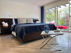 een slaapkamer met een groot bed en een tafel bij Suite de lujo con naturaleza y BBQ cerca de Cuenca in Cuenca +107 foto's