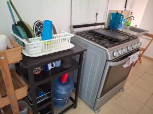 eine Küche mit einem Herd und einer Theke mit Geschirr in der Unterkunft Comfortable apartment in Huatulco in Bahías de Huatulco + 6 Fotos