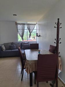 ein Wohnzimmer mit Tisch und Couch in der Unterkunft Comfortable apartment in Huatulco in Bahías de Huatulco