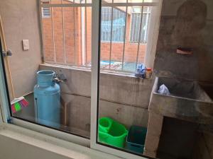 Ein Fenster mit einem grünen Eimer neben einem Waschbecken in der Unterkunft Comfortable apartment in Huatulco in Bahías de Huatulco