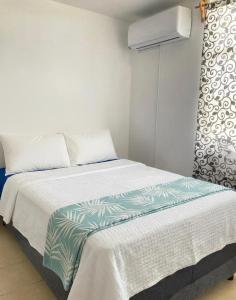 ein Schlafzimmer mit einem Bett mit einer grünen und weißen Decke in der Unterkunft Comfortable apartment in Huatulco in Bahías de Huatulco