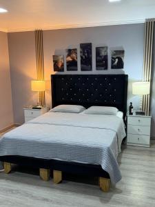 a bedroom with a large bed with two lamps and pictures on the wall at Spa la casona de pirque in Pirque +24 photos