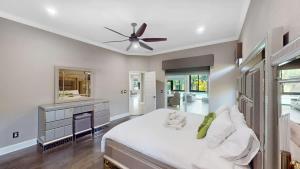a bedroom with a white bed and a ceiling fan at The Riverview Estates Sauna And Heated Pool in Riverview