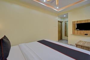 a bedroom with a bed and a flat screen tv at Collection O Ketan Regency Near Acropolis Mall in Kolkata +29 photos
