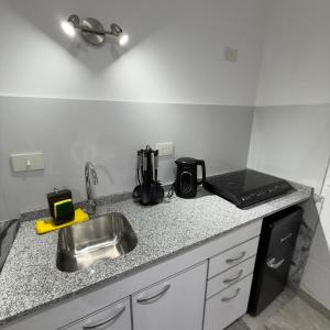 a kitchen counter with a sink and a stove at Espacio Uno B in Belén de Escobar +8 photos