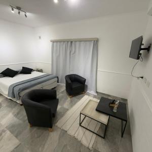 a bedroom with a bed and two chairs and a table at Espacio Uno B in Belén de Escobar