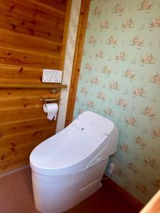 a white toilet in a bathroom with wooden walls at オシドリ in Shirahama