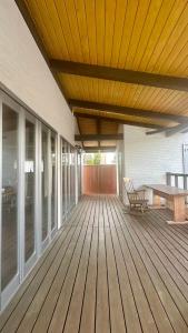 a wooden deck with a bench and a wooden table at オシドリ in Shirahama