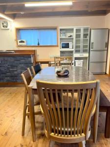 a kitchen with a dining room table and chairs at オシドリ in Shirahama