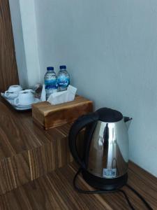 een theepot op de grond naast waterflessen bij rajaampatguesthouse in Pulau Saonek-kecil