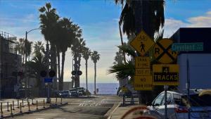 a street with traffic signs and palm trees and the ocean at Retro Star-Wagon, Ocean View at Studios in Oceanside