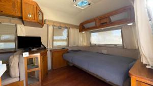 a small bedroom in an rv with a bed and a television at Retro Star-Wagon, Ocean View at Studios in Oceanside